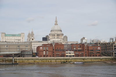 Buildings at waterfront against sky in city