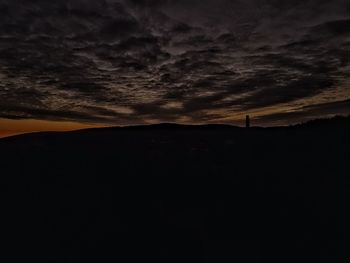 Scenic view of silhouette field against sky at sunset