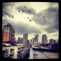 View of cityscape against cloudy sky