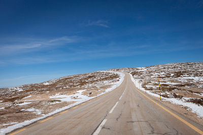 Scenic view of empty road against cloudy sky