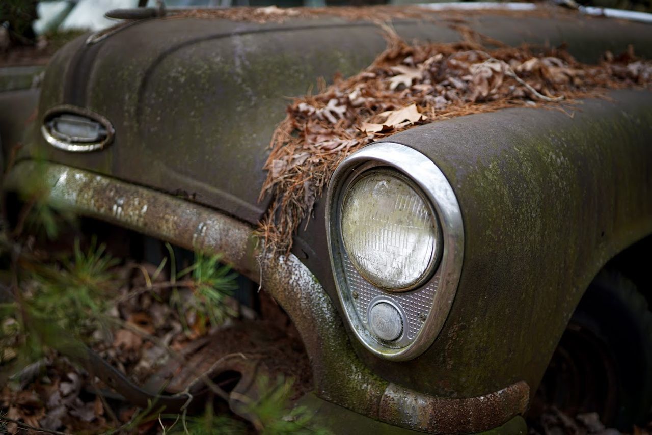 CLOSE-UP OF VINTAGE CAR ON LAND