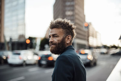 Bearded businessman with brown hair at street