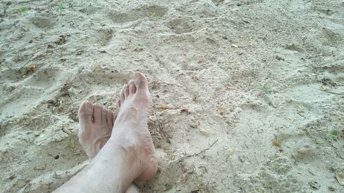 Low section of person legs on sand at beach