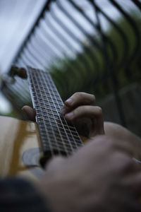 Cropped image of hands playing guitar