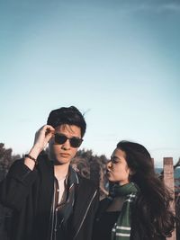 Young couple standing against sky
