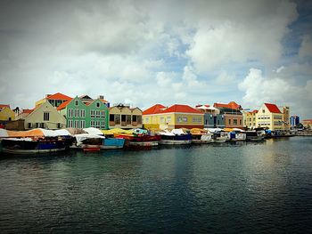 Boats moored at harbor against sky