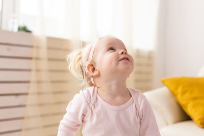 Portrait of cute girl looking away while lying on bed at home