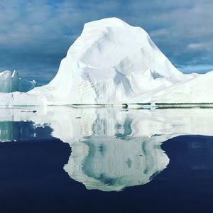 Glacier in lake against sky