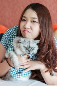 Portrait of woman with kitten at home