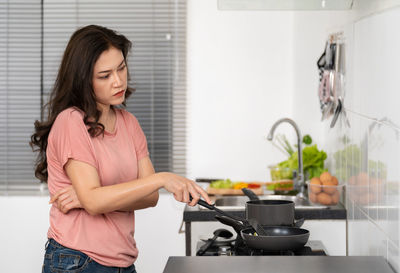 Sad woman preparing food at home