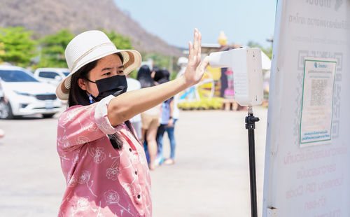 Side view of young woman standing in park