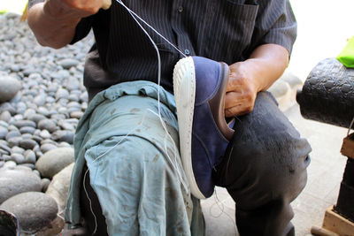 Low section of man working on rock