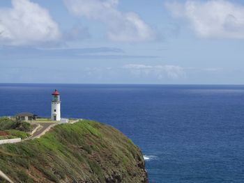 Lighthouse by sea against sky