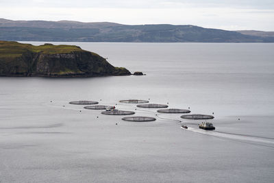 Aquaculture fish farm with approaching boat  in scotland