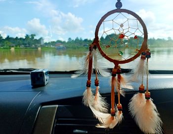 Close-up of clothes hanging in car against sky