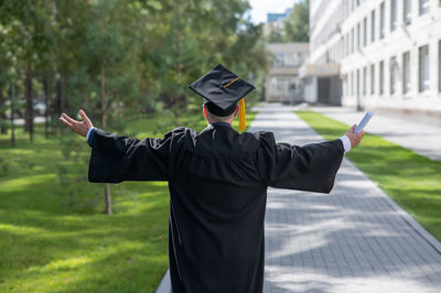 Rear view of man wearing hat standing in park