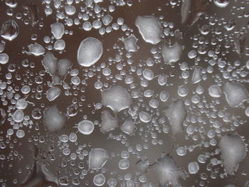 Full frame shot of wet glass with rain drops