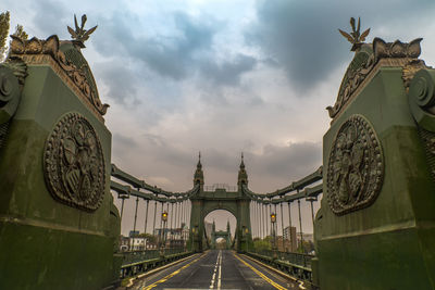 Statue of bridge against cloudy sky