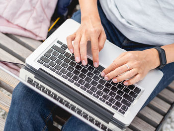 Woman with laptop on park bench.freelancer at work.student learns from outdoors. modern lifestyle.