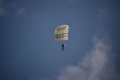 Low angle view of person paragliding against sky