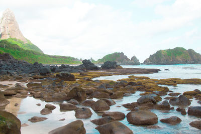 Scenic view of sea by cliff against sky