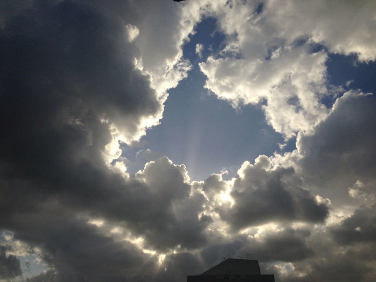 sky, cloud - sky, low angle view, cloudy, weather, cloud, cloudscape, beauty in nature, nature, overcast, building exterior, built structure, scenics, architecture, sunbeam, sunlight, outdoors, high section, dramatic sky, silhouette