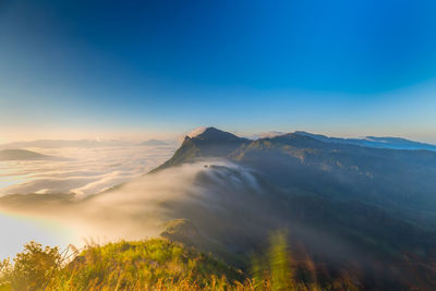 Scenic view of mountains against blue sky