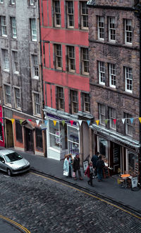 People walking on street by buildings in city