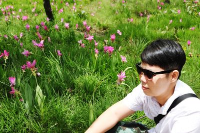 Woman wearing sunglasses while sitting on grassy field