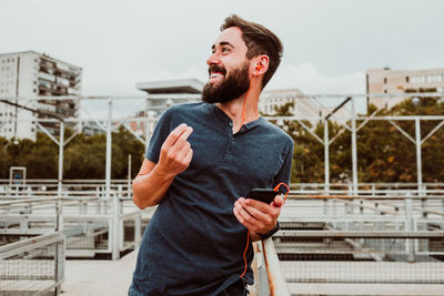 Young man using mobile phone in city