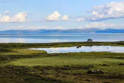 Scenic view of lake against cloudy sky