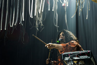 Man with arms raised standing in music concert