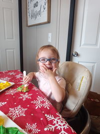 Portrait of cute smiling girl sitting at home