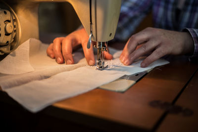 Midsection of person working on sewing machine