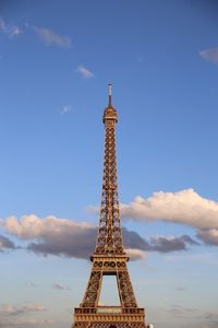 Low angle view of communications tower against cloudy sky