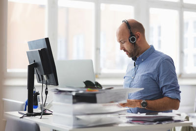 Businessman wearing headphones working at desk in office