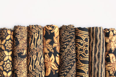 Close-up of clothes hanging on wood against white background