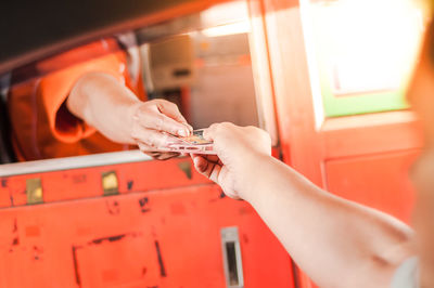 Close-up of hands giving money at ticket counter