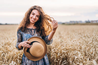 Smiling young woman standing in field