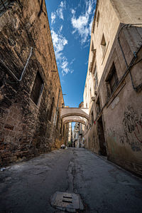 Road amidst buildings against sky