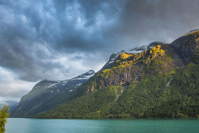 Scenic view of lake by mountain against sky