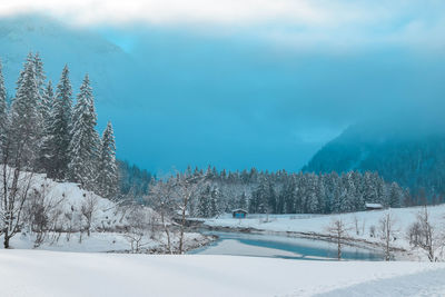 Snow covered land and mountains against sky