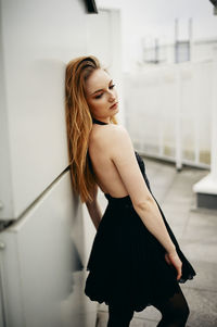 Woman near the wall in a black dress