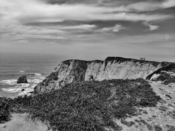 Rock formations by sea against sky