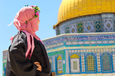 Rear view of woman standing at temple