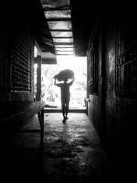 Rear view of woman standing in corridor