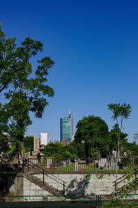 Buildings in city against clear blue sky