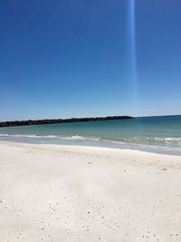 Scenic view of beach against clear blue sky