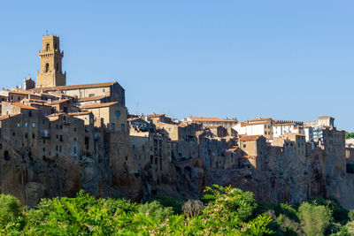 Little beautiful medieval town pitigliano in tuscany, italy against blue sky