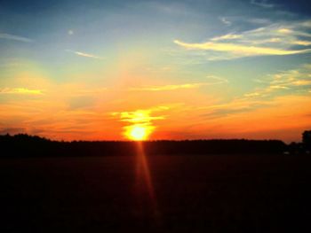 Scenic view of silhouette field against sky during sunset